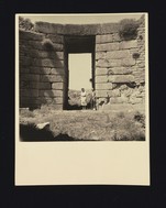 Lion Tomb: A. J. B. Wace and unidentified woman standing in doorway of chamber, with a view out to the dromos