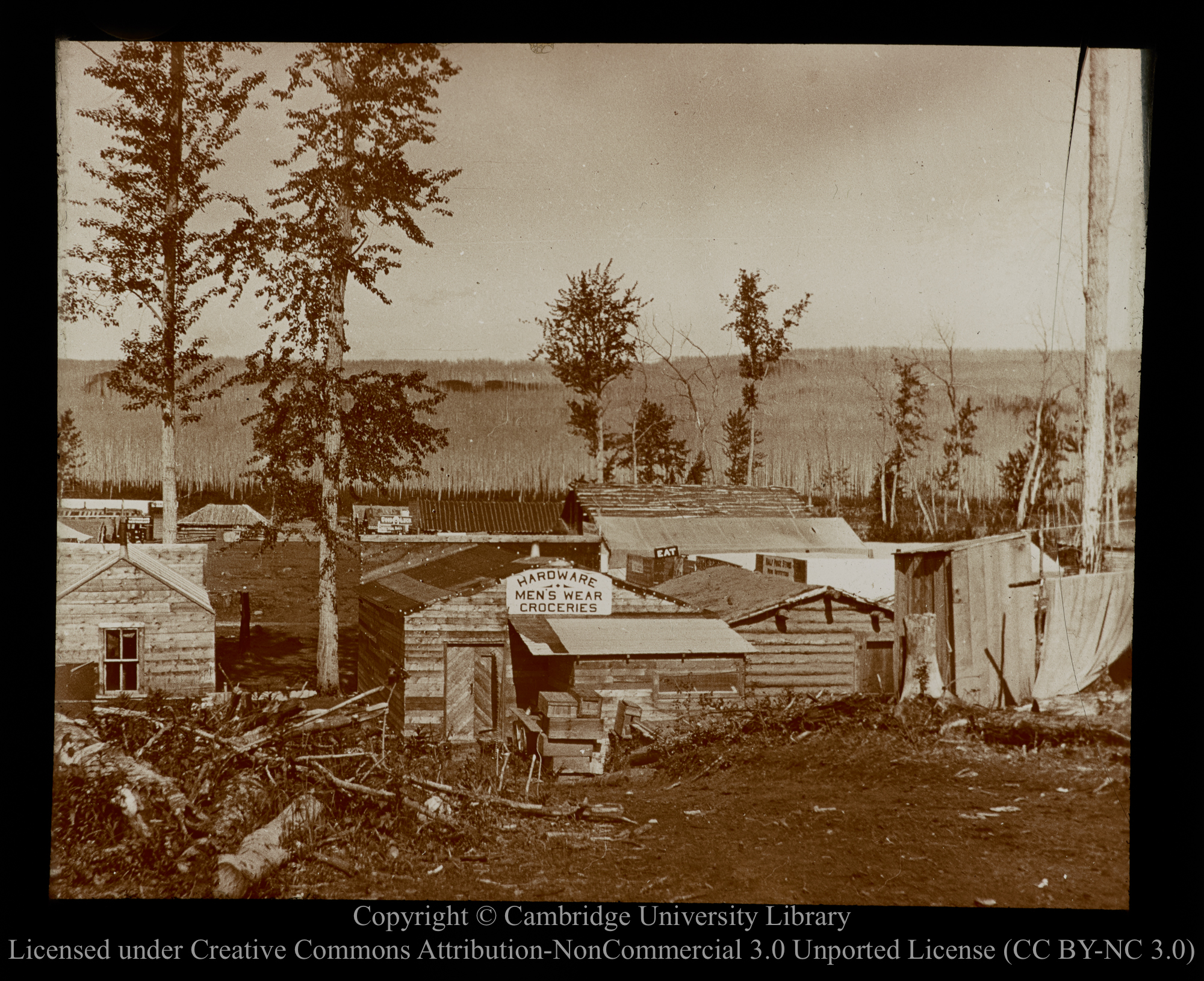 [Timber shack settlement, with signboard reading &#39;Hardware, Men&#39;s Wear, Groceries&#39;], 1910 - 1930